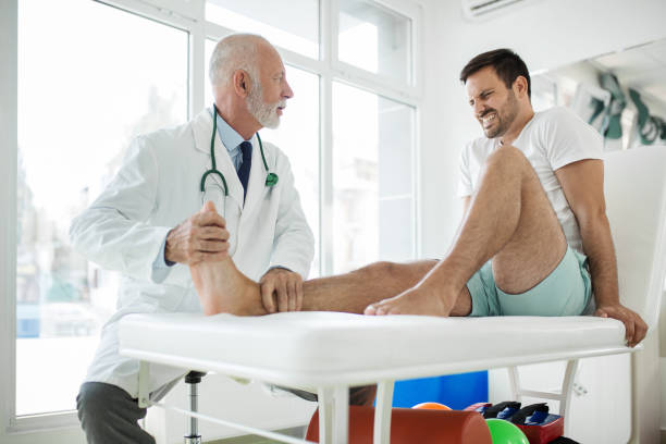 istock Young man having his ankle examined by a doctor. 1457631095