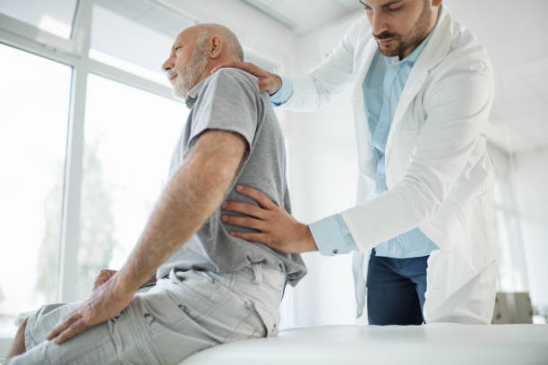 Doctor examining patient's back stock photo