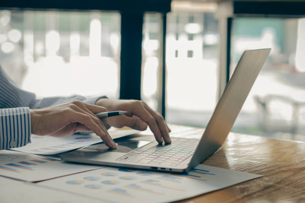 istock Businessman hands on keyboard of laptop computer showing data analysis graph Businessman working and analyzing financial figures on graph document 1457639625