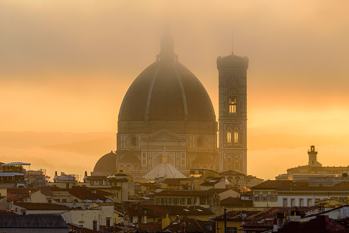 The Florence Cathedral in a golden misty sunrise early morning.