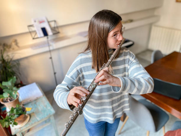 jeune adolescente jouant de la flûte traversière - flûte traversière photos et images de collection