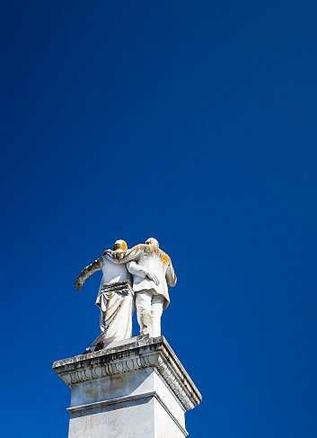 Betanzos, Spain_June 1, 2011: Statue of García Naveira brothers, Betanzos, Coruña, Galicia, Spain. 2 Spanish philanthropists founders of many charities in the early twentieth century. Clear blue sky background.