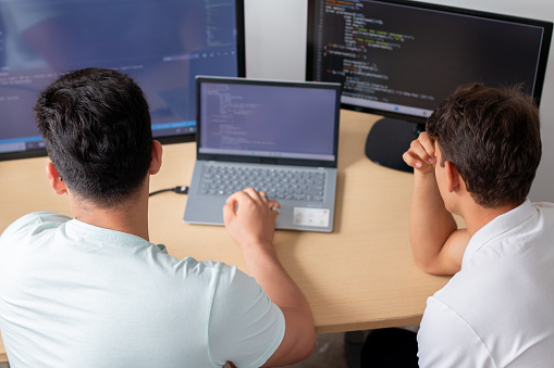 Two Young Programmers In An Office Preoccupied As They Work On A ...
