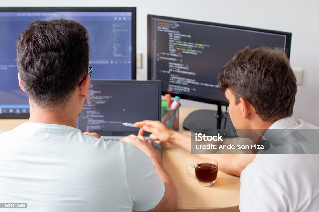 A Computer Programers Two Young Programmers Work On A Programming Project On A Modern Desktop ...