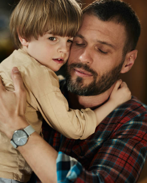 istock Loving single father embracing his son at home. 1457643977