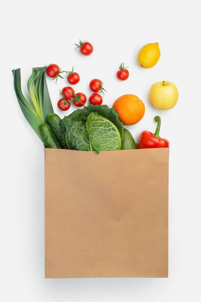 paper bag with groceries on a white isolated background paper bag with groceries on a white isolated background paper bag stock pictures, royalty-free photos & images