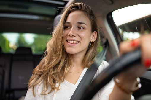 Beautiful smiling woman driving a car.