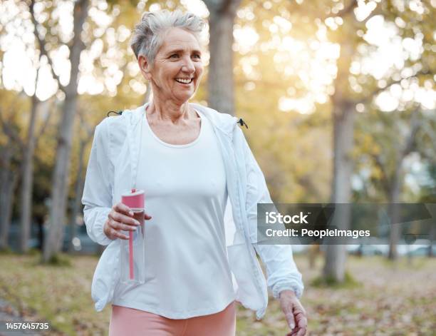 Fitness Nature And Senior Woman With Water Bottle For Wellness Hydration And Minerals For Walking In Park Health Retirement And Elderly Female Doing Workout Exercise And Cardio Training Outdoors Stock Photo - Download Image Now