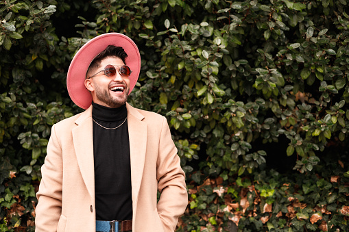 portrait of fashionable gay latin man laughing, copy space