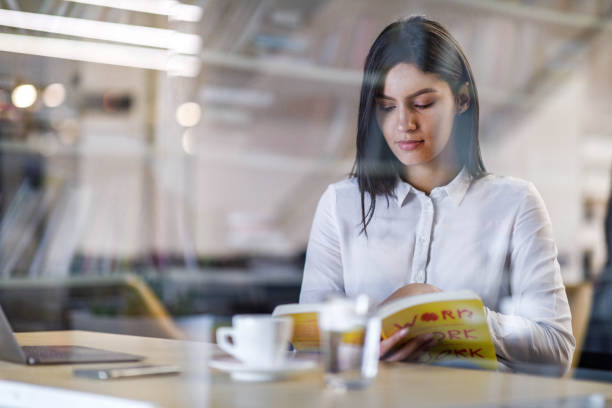 istock Young college student reading a book at home. 1457645860