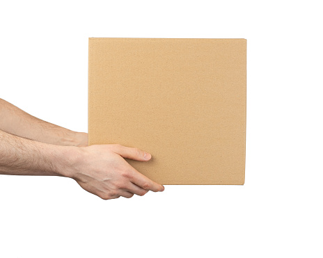 Caja de cartón en manos masculinas aisladas sobre fondo blanco photo