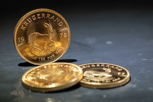 gold krugerrand coins isolated on gray background
