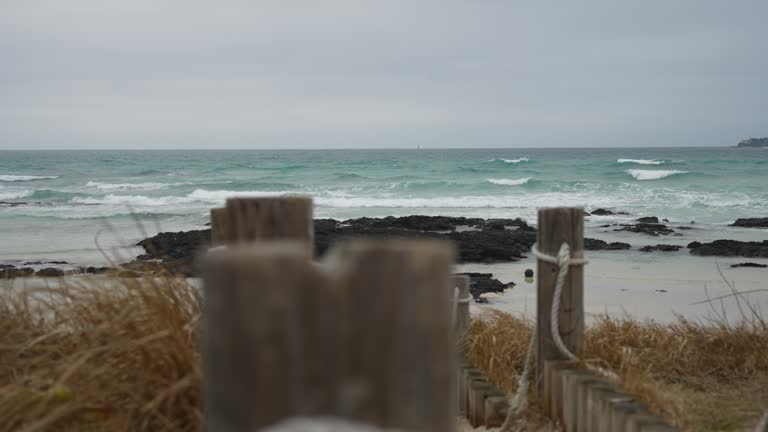 Sand and waves at Jeju Island Beach in Korea on a windy and cloudy day