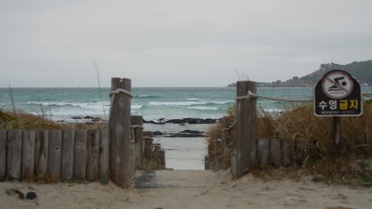 Sand and waves at Jeju Island Beach in Korea on a windy and cloudy day