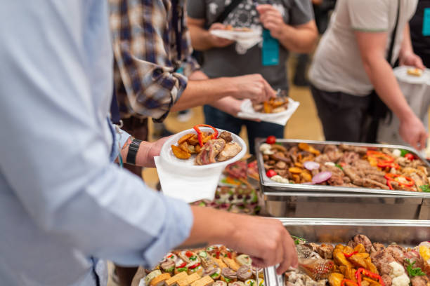 istock Man holding plastic plate and scooping food at buffet table catering in hotel or restaurant. Self service meal concept. 1457654656