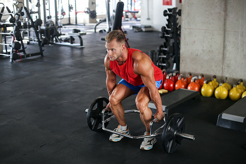 Muscular young man exercising in a gym. About 25 years old, Caucasian male.