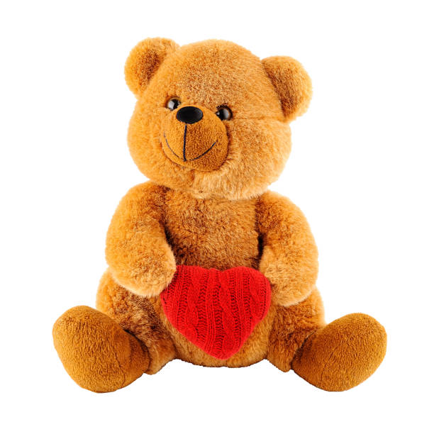 istock Soft toy teddy bear holding a heart-shaped pillow isolated 1457656757