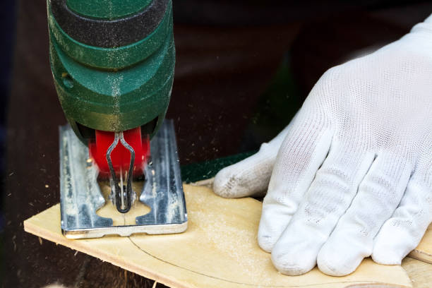 istock Men working with electric jigsaw and wooden plank 1457656808