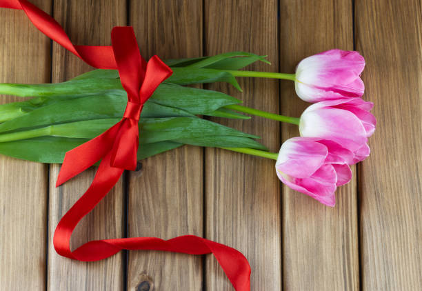 istock Pink tulips with red ribbon 1457657207