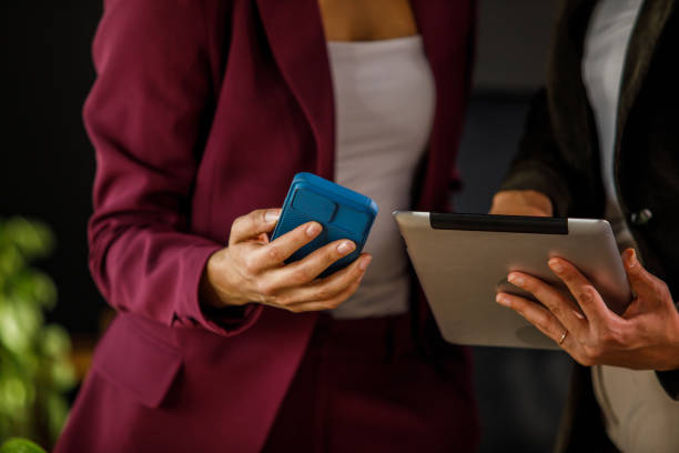 istock Two businesswomen exchanging data via smart phone and digital tablet 1457661223