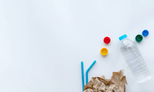 istock Recycling concept of reusing products. Plastic bottle, caps, straw are over white background. Flat lay banner with copy space for text 1457661473