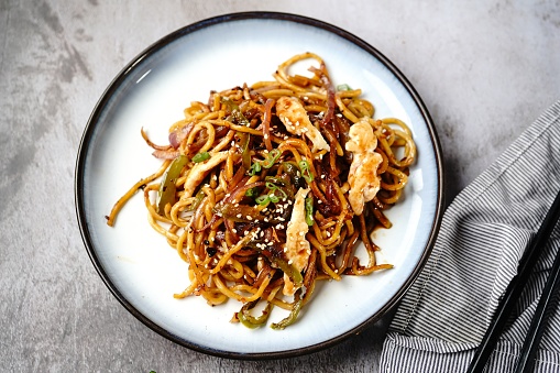Chicken Lo mein noodles topped with toasted sesame seeds and spring onions