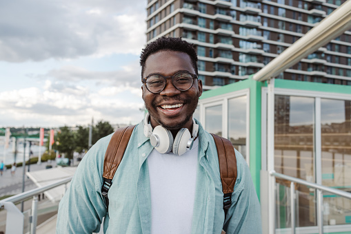 Photo of African American man wearing backpack and smiling