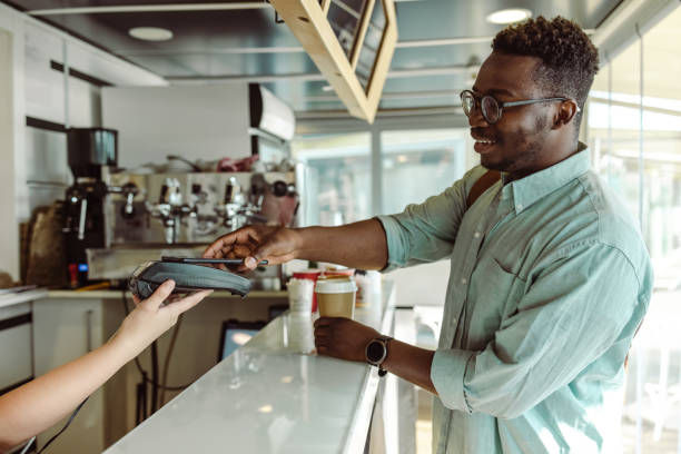 istock An African American young man paying for coffee in cafeteria 1457663879