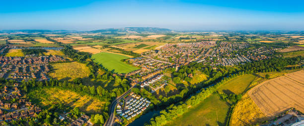 panorama aereo sopra le case suburbane pascolo verde campi coltivati dorati - vale of evesham foto e immagini stock