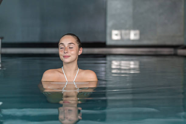 istock Glad woman in clear pool water 1457670945