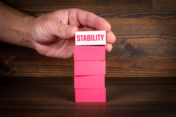 istock Stability Concept. Pink blocks in a pile on a wooden texture background 1457672943