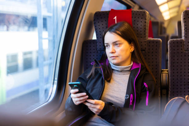 istock Woman traveler using her smartphone in train 1457678831