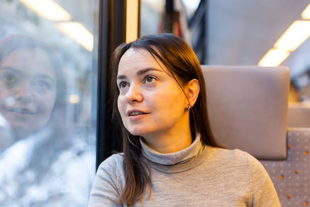 istock Female traveler looking with interest at scenery outside train window 1457678844