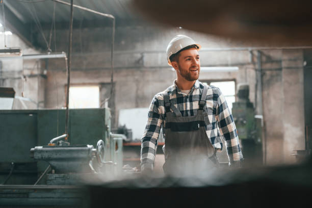 istock Front view. Factory male worker in uniform is indoors 1457683689