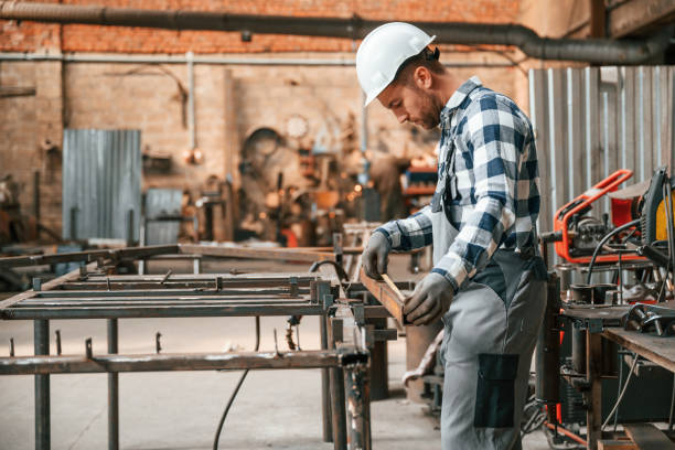 istock Using professional tools. Factory male worker in uniform is indoors 1457685536