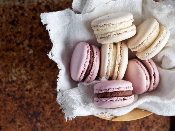 pink macaron with chocolate cream filling on white cloth