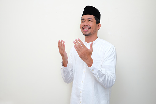 Moslem Asian man smiling and showing grateful gesture