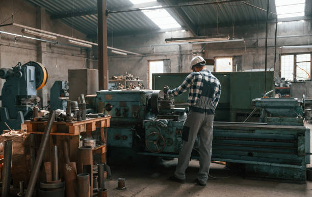 istock Back view. Factory male worker in uniform is indoors 1457686588