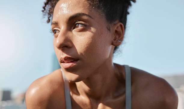 face, sweat and fitness with a sports black woman tired after a cardio workout for fitness in the city. running, exhausted and sweating with a female athlete or runner resting after exercise in town - women sweat healthy lifestyle exercising imagens e fotografias de stock