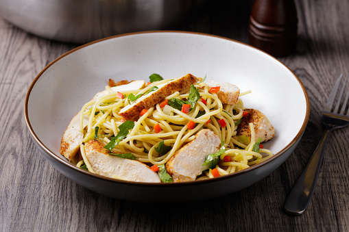 close view of Chinese style spring onion, chilli oil spaghetti with pan fried chicken breast