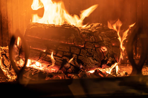 istock Log of wood burning in a fireplace inside a house, hearth 1457688513