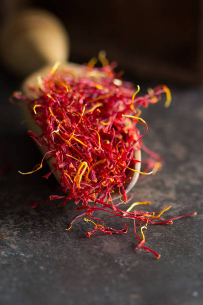 istock a heap of red vibrant saffron string on a wooden spoon on a dark surface 1457689208