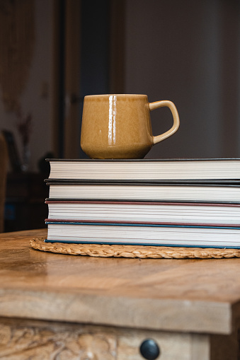 brown cup on books on wooden table