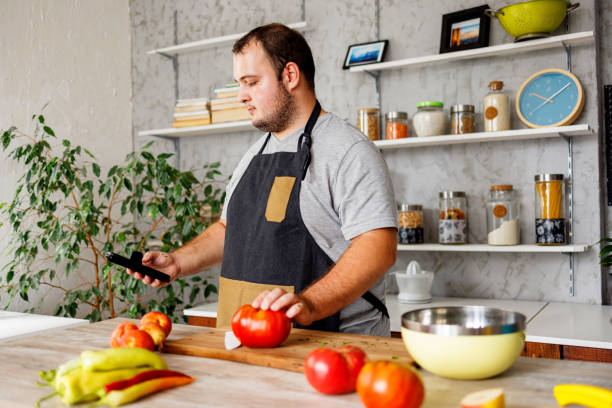 istock Overweight man using smartphone for searching healthy recipe online 1457691358