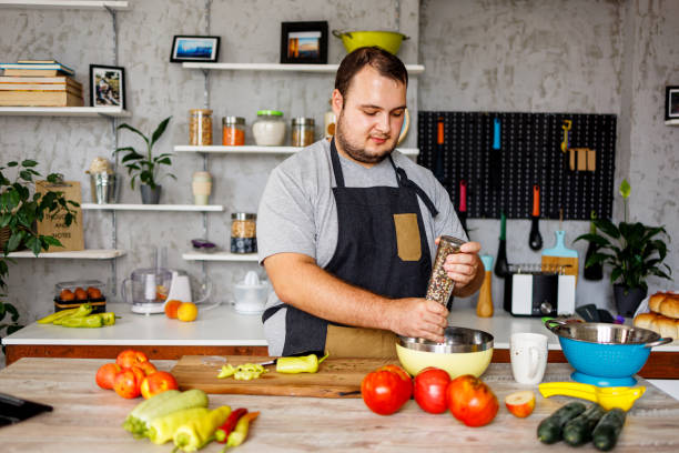 istock Overweight man puts pepper in food 1457691640