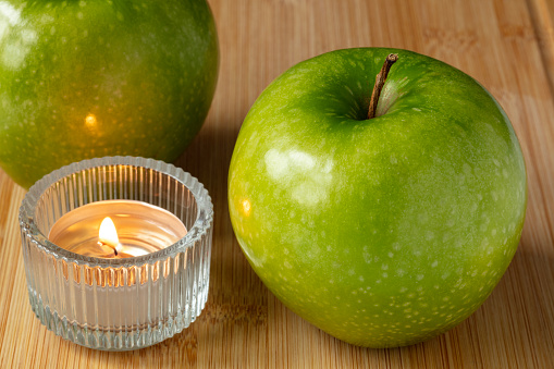 Two Granny Smith Apples on Cutting Board with Tea light Candle