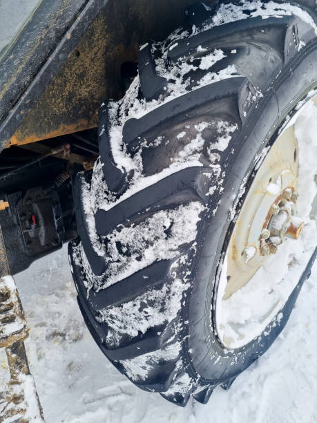 istock large wheels of a blue tractor in a snowy forest. 1457695734