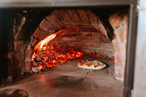 Preparing pizza at home in a brick oven