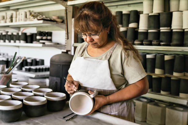 istock Craftswoman making the sgraffito on a piece of pottery. 1457697867