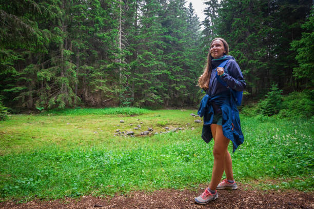 istock Young smiling woman walking on footpath in the forest 1457697974
